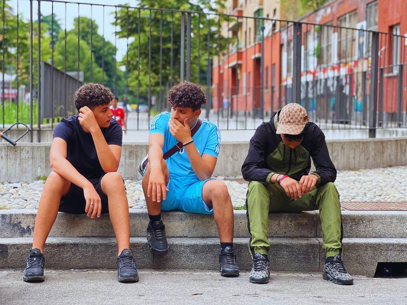 Tre ragazzi seduti su una gradinata