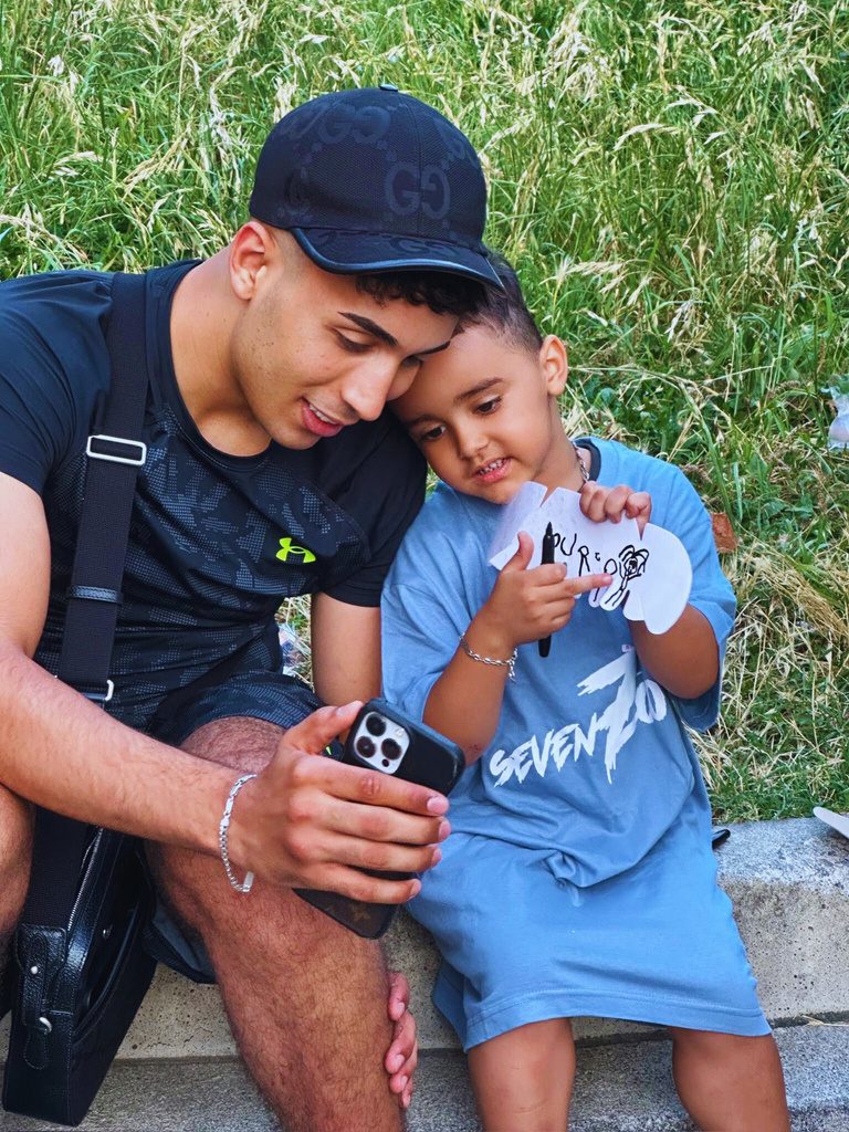 Un giovane e un bambino osservano insieme un telefono