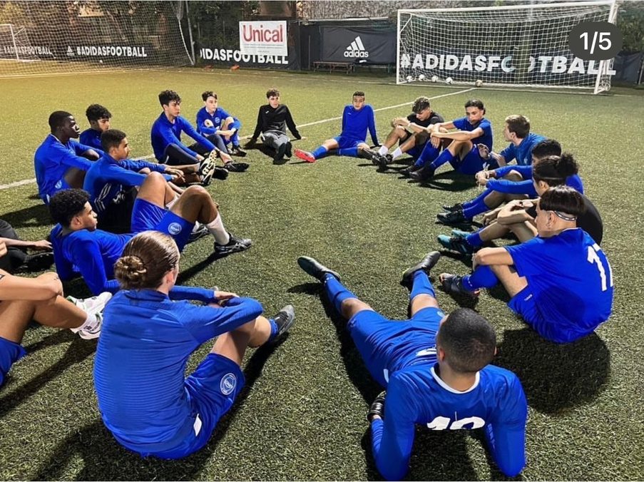 Squadra di ragazzi seduta in cerchio sul campo